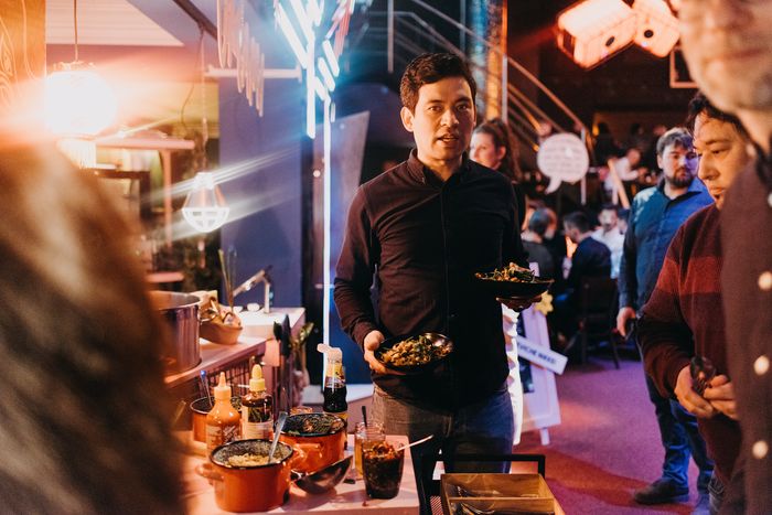 Servicekraft reicht Fingerfood im Neonambiente des Delphi Showpalast