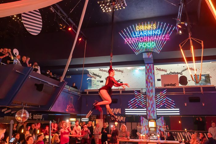 Vertikaltuch-Artistin in Rot unter der Neondecke des Delphi Showpalast Hamburg