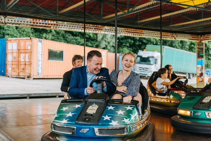 Lachende Gäste im Autoscooter beim Firmenfest auf dem Jahrmarkt der Kuppel