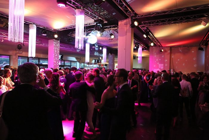 Tanzende Gäste bei einer Firmenparty in der Eventhalle der MIGNON Trabrennbahn