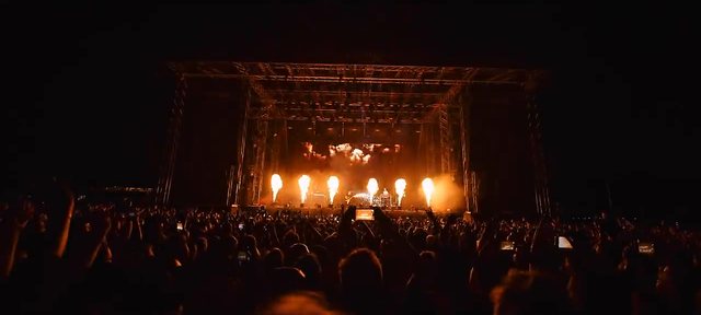 Open-Air-Konzert bei Nacht auf der MIGNON Trabrennbahn: Bühne mit Flammeneffekten vor Tausenden Gästen