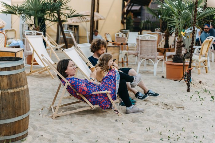 Gäste in Liegestühlen im Strandbereich beim Sommerfest auf dem Areal