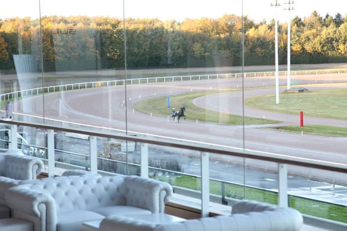 Sulky Lounge mit weißen Chesterfield-Sofas und Blick auf die Rennbahn