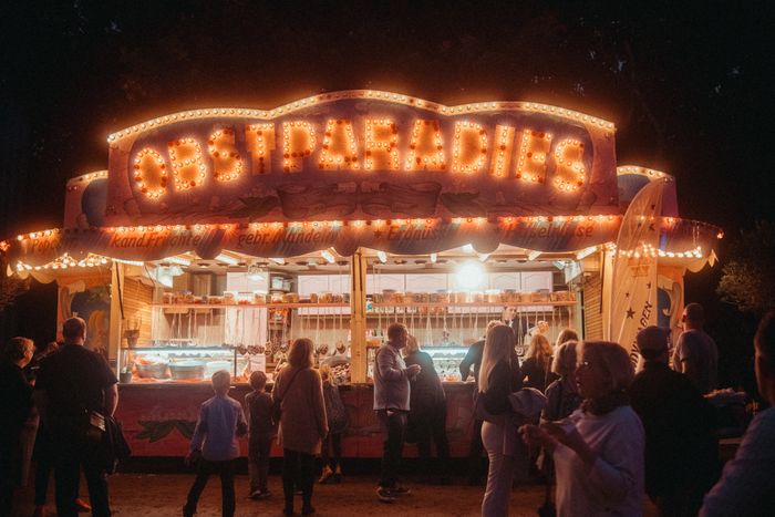 Beleuchtetes historisches Fahrgeschäft beim Jahrmarkt der Kuppel am Abend