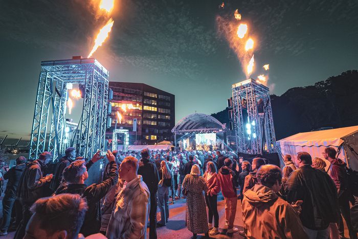 Feuerfontänen über der Bühne bei einer Abendshow am Platz am Fischereihafen in Hamburg