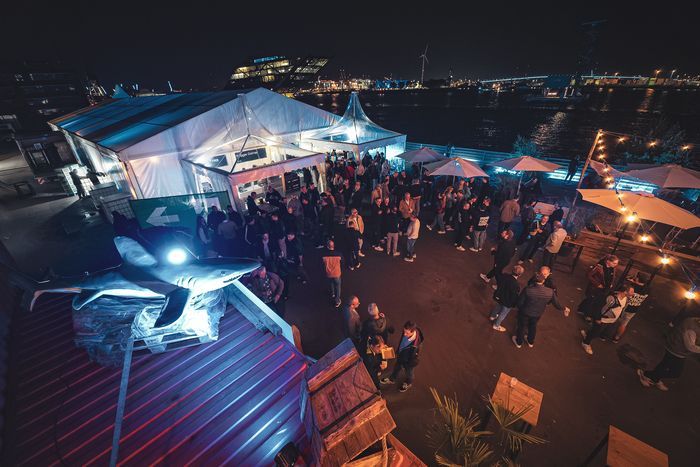 Luftbild des nächtlichen Events am Fischereihafen mit beleuchteter Eventkuppel am Hamburger Hafen