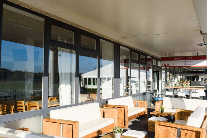 ADA Lounge der Trabrennbahn Bahrenfeld mit Sofas und Blick auf die Rennbahn