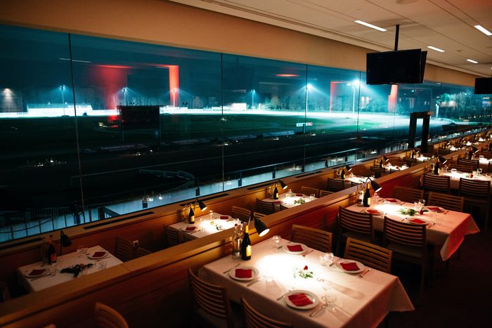 Gedeckte Dinnertische mit Blick auf die nächtliche Trabrennbahn Bahrenfeld