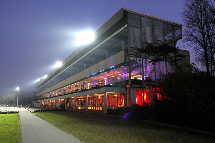 Beleuchtetes Tribünengebäude der Trabrennbahn Bahrenfeld bei Nacht