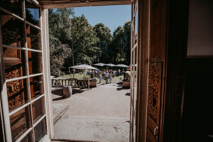 Blick durch die Flügeltüren der Villa Mignon auf das Gartenfest auf der Terrasse